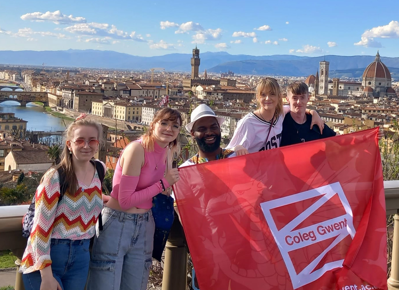 Students abroad in Italy holding Coleg Gwent flag
