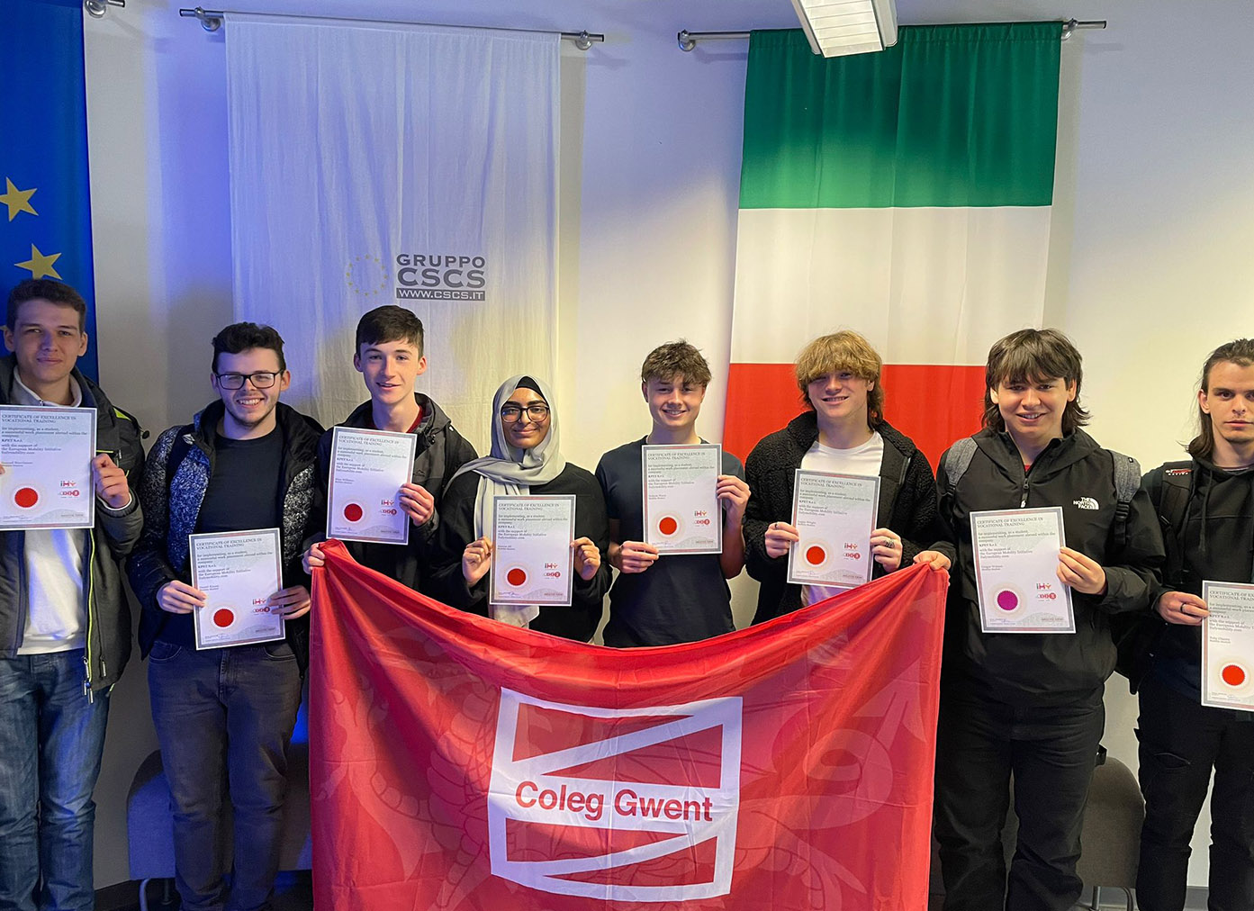 Overseas programme students holding Coleg Gwent flag