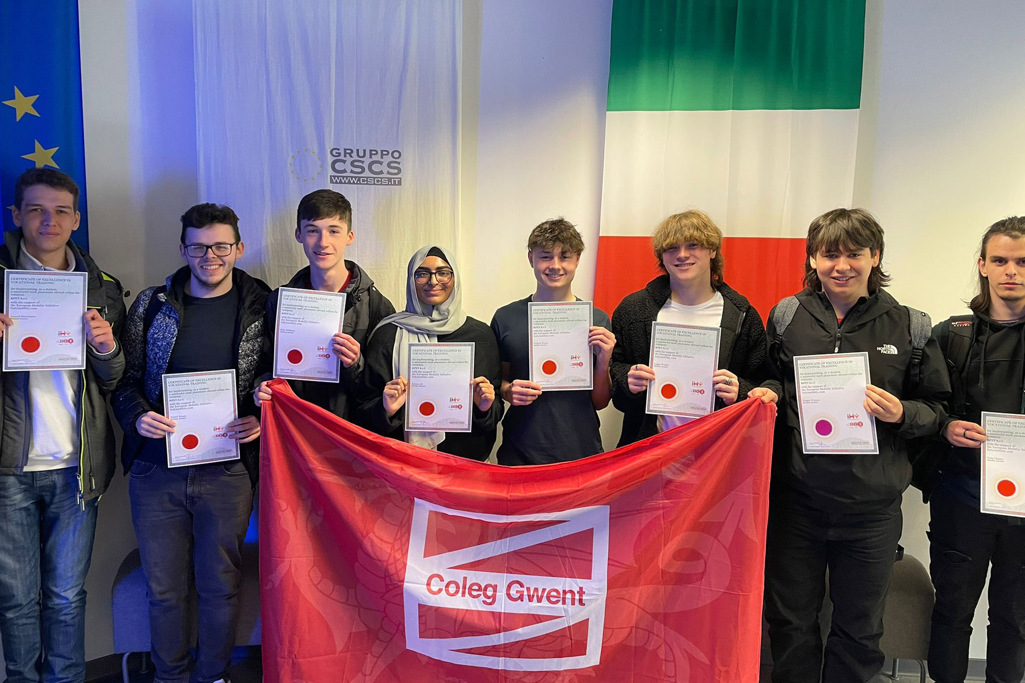 Overseas programme students holding Coleg Gwent flag