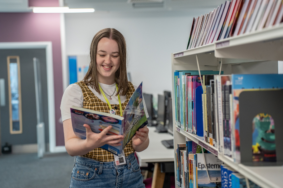 Student in TLZ library looking at book
