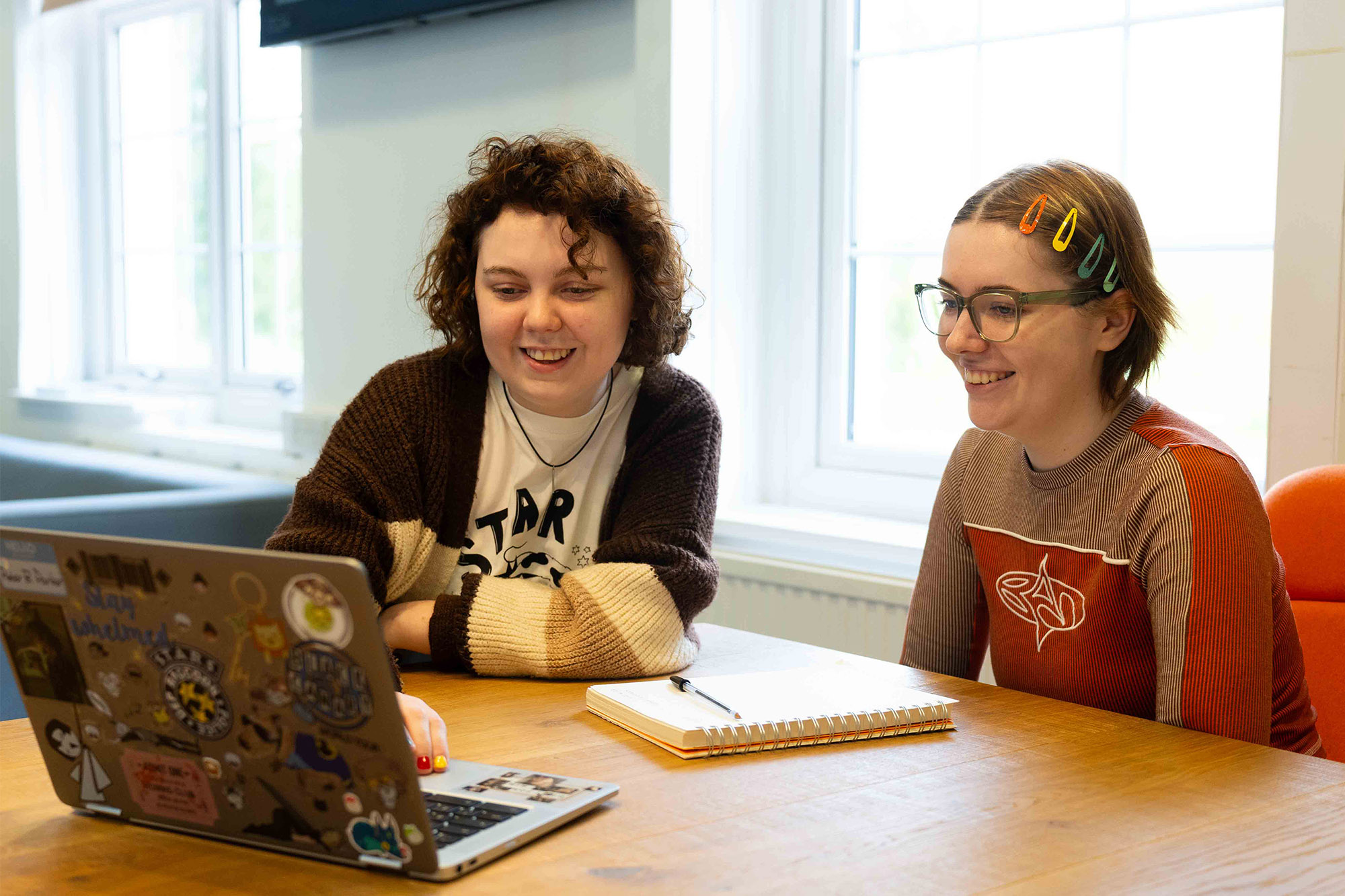 Students sat at a desk, looking at a laptop
