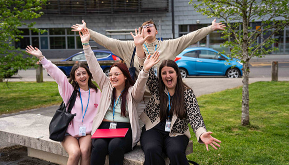 students at college smiling outside