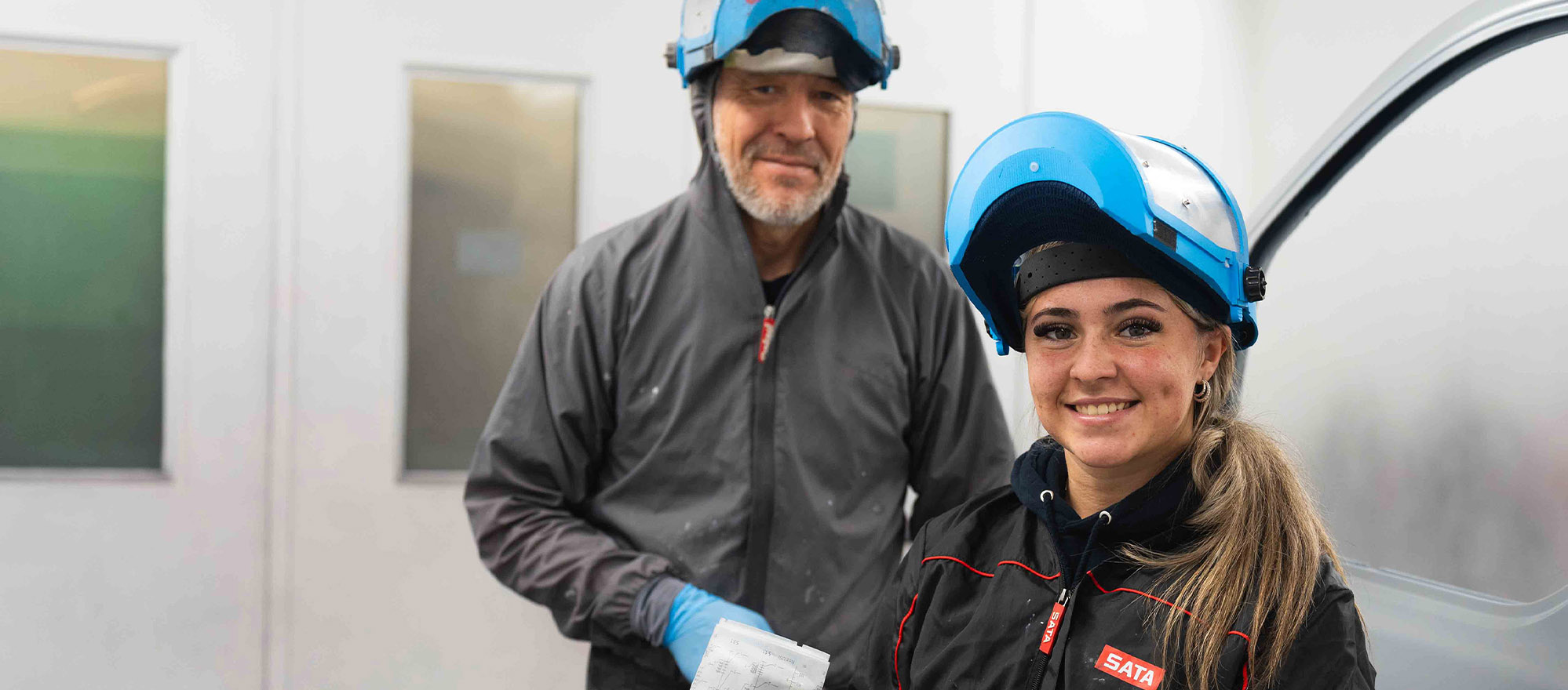 Apprentice and tutor in a spray booth