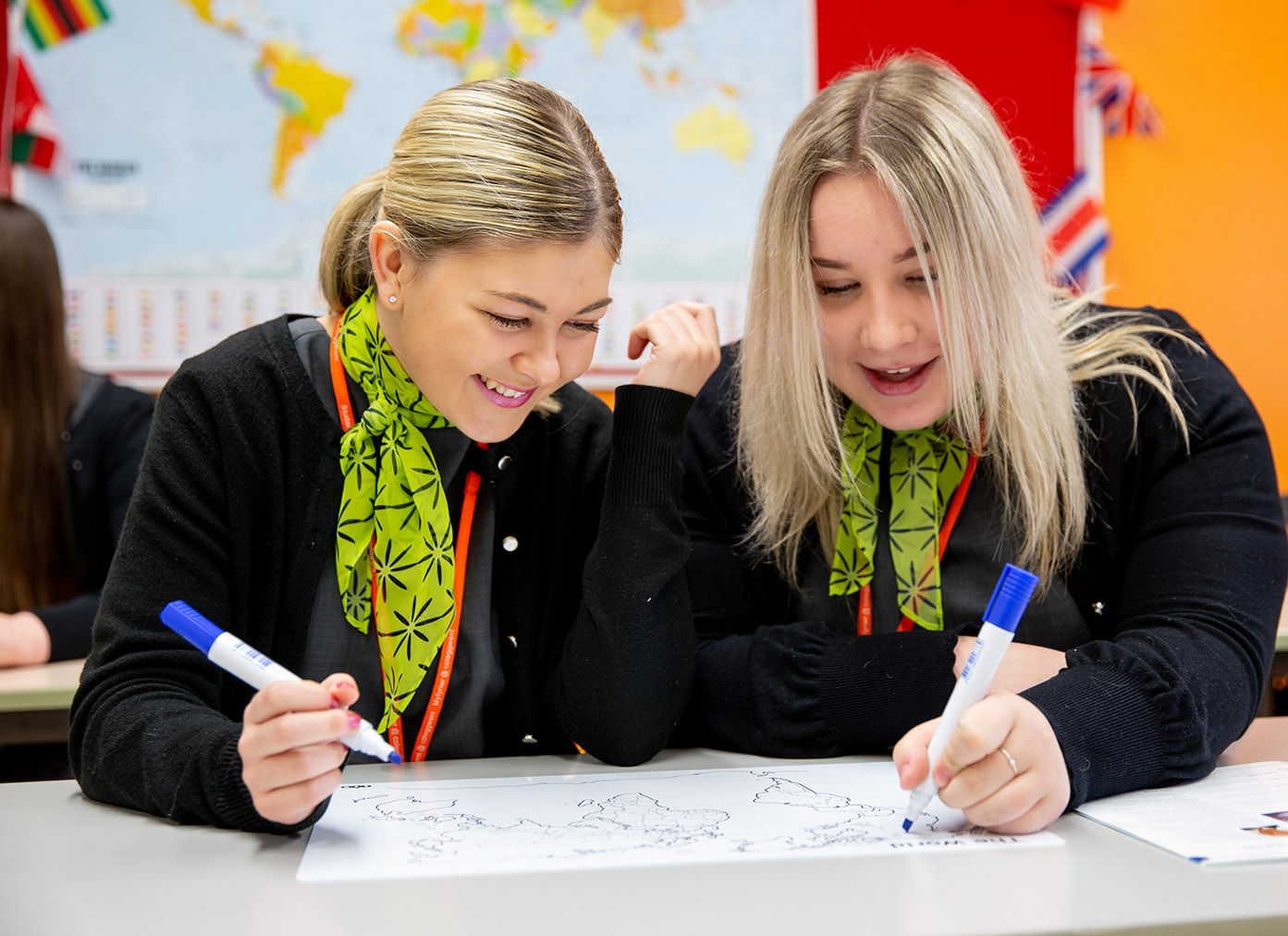 Two Travel and Tourism students working on flowchart in classroom