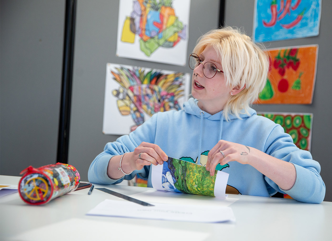 Art student surrounded by paintings in class