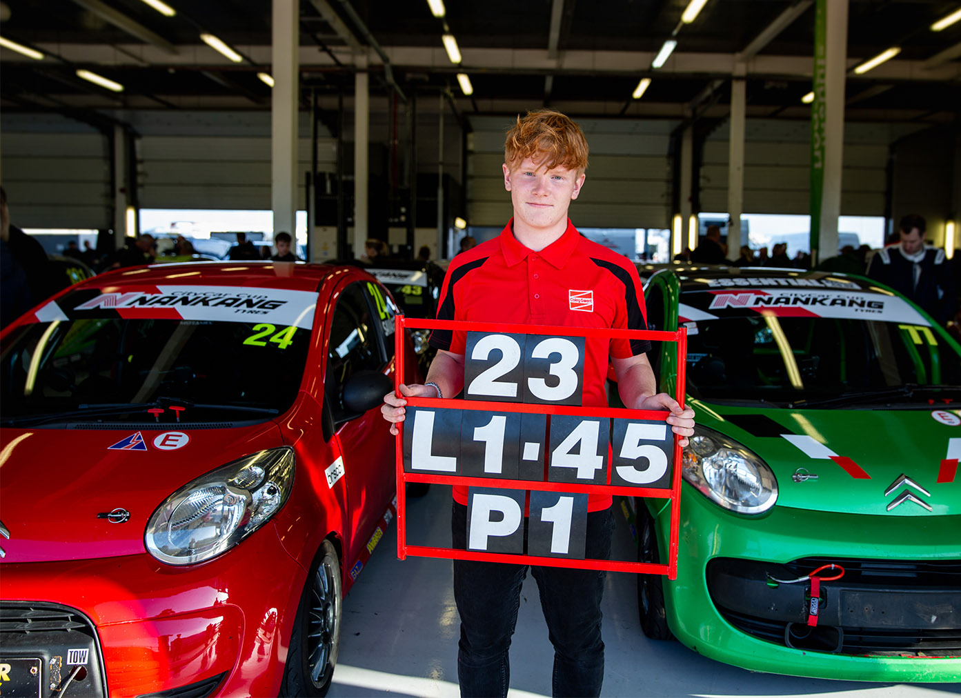 Automotive student stood in a rally car pit area
