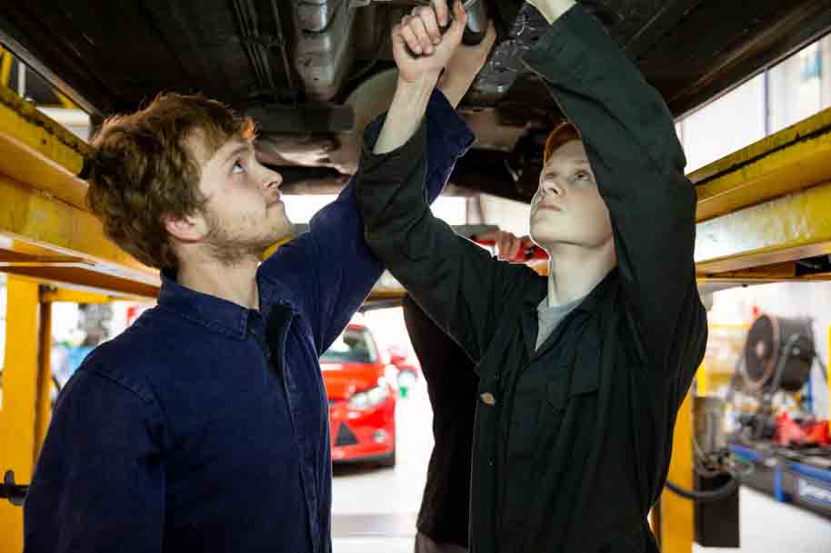 Students fixing the underneath of the car