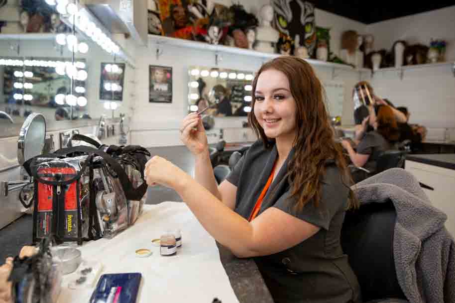 Student in front of makeup mirror