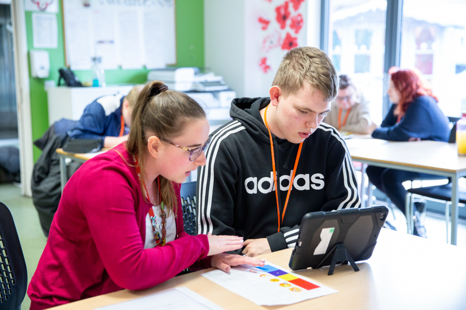 Tutor helping student on laptop