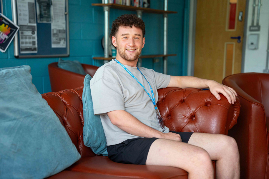 Student relaxing in HE Hub