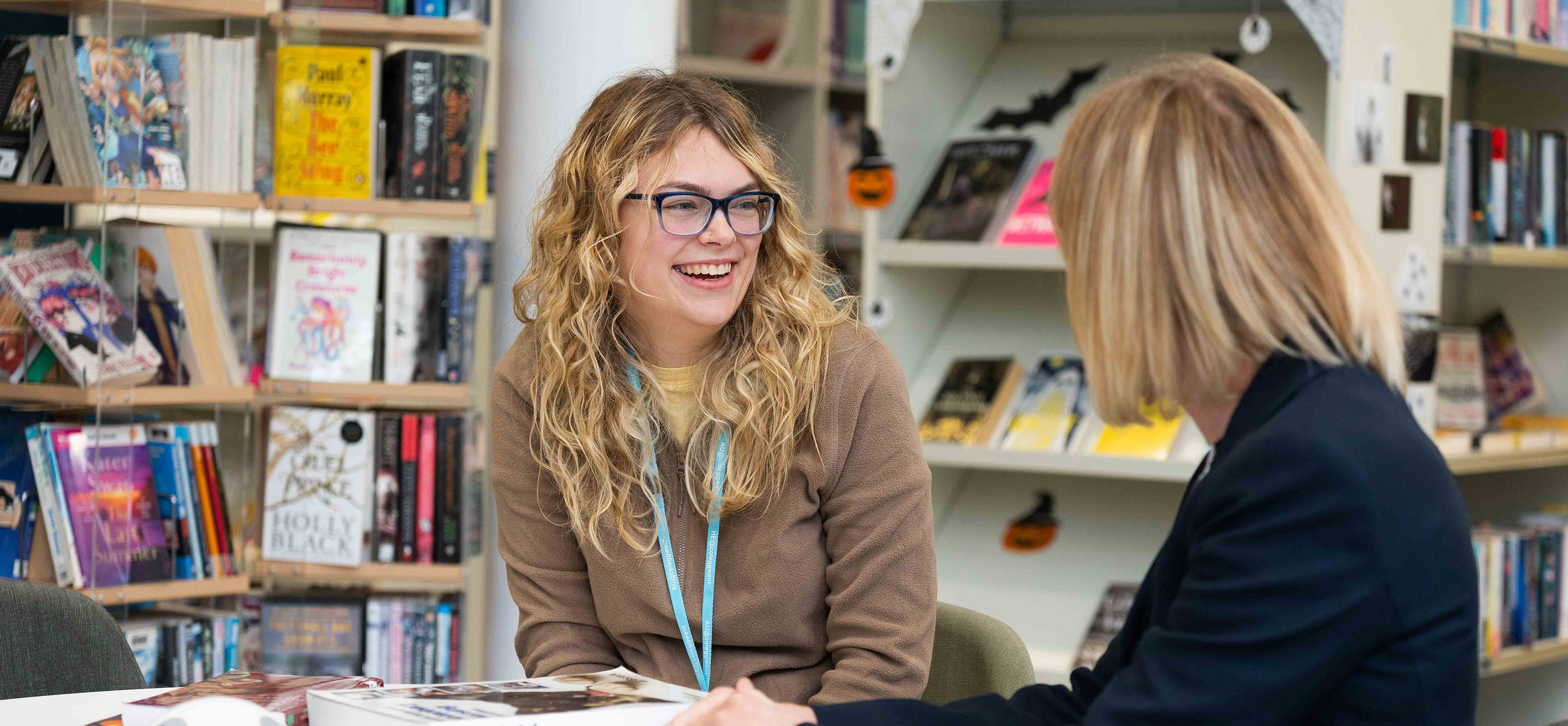 Student talking to staff in the library