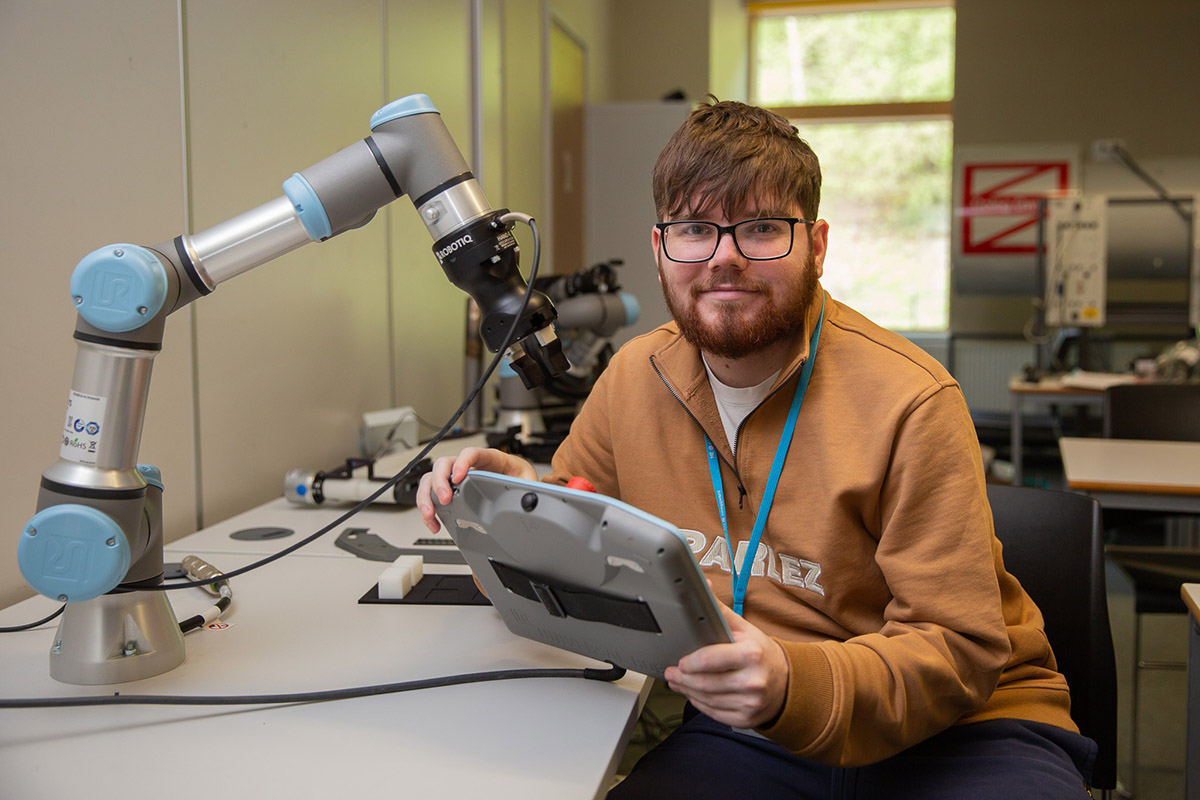 Student using a tablet and robotic machinery