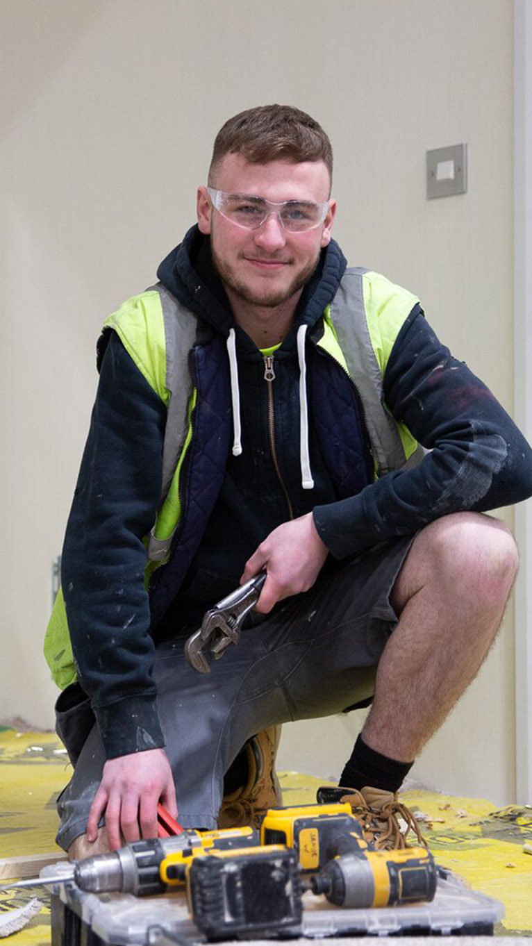 Apprentice with construction tools in workplace