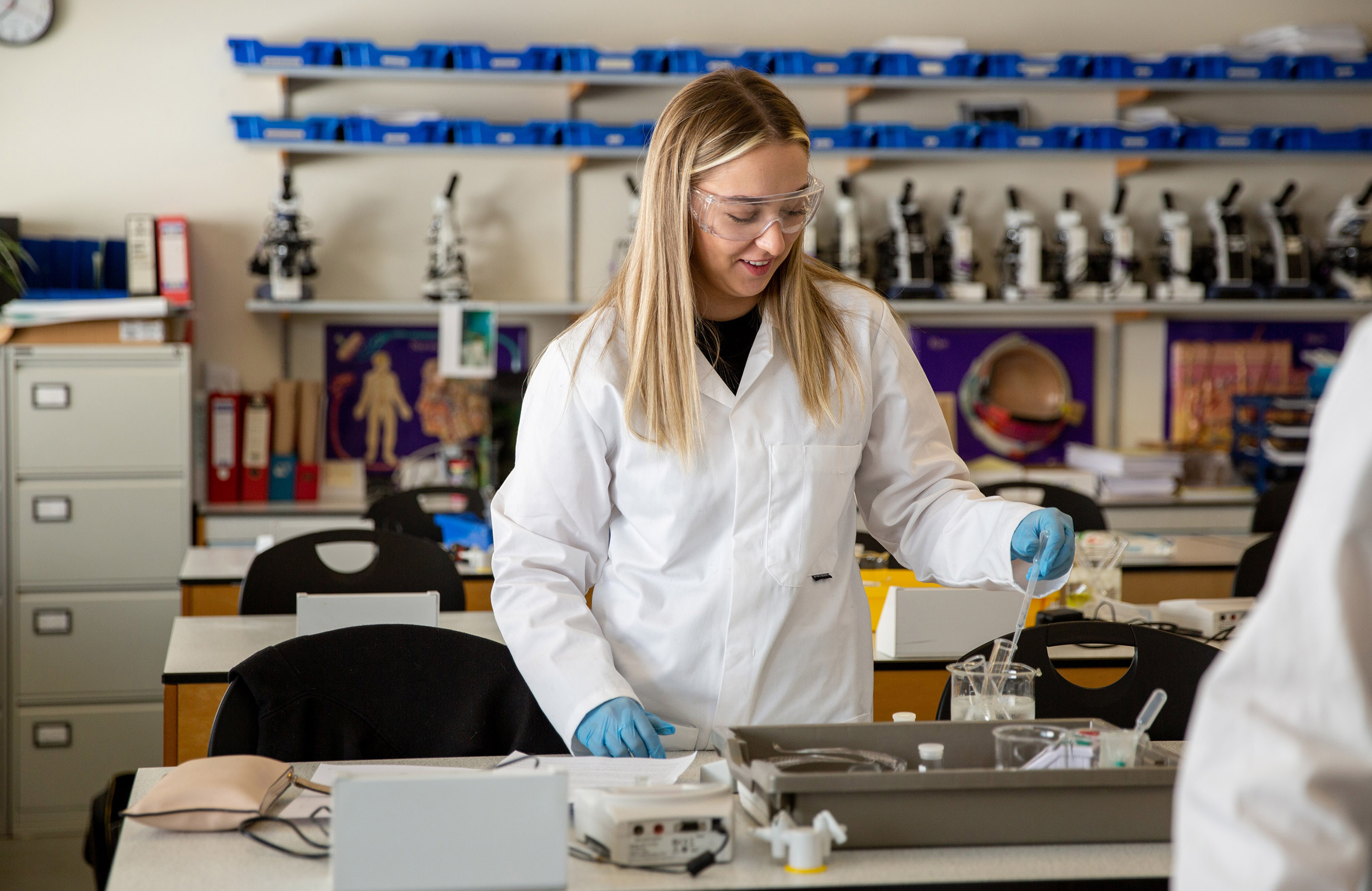 Student in lab holding a pipette