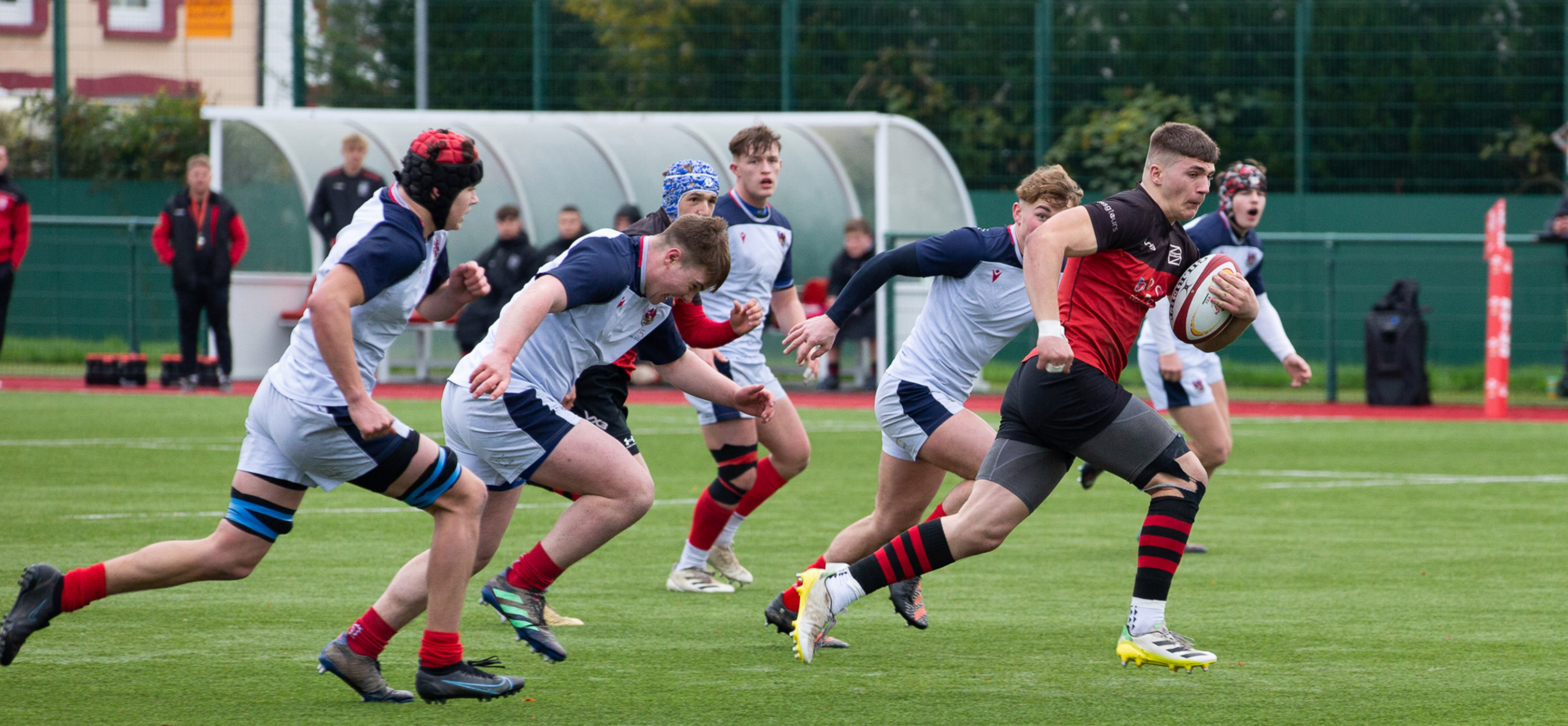 Dragons academy rugby player running with the ball